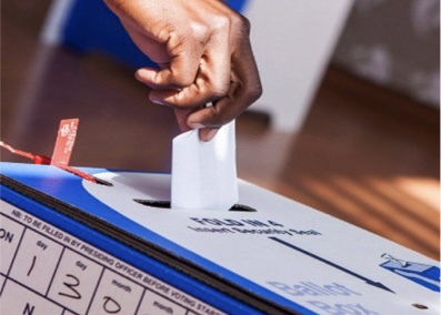 Individial casting their vote in a voting box