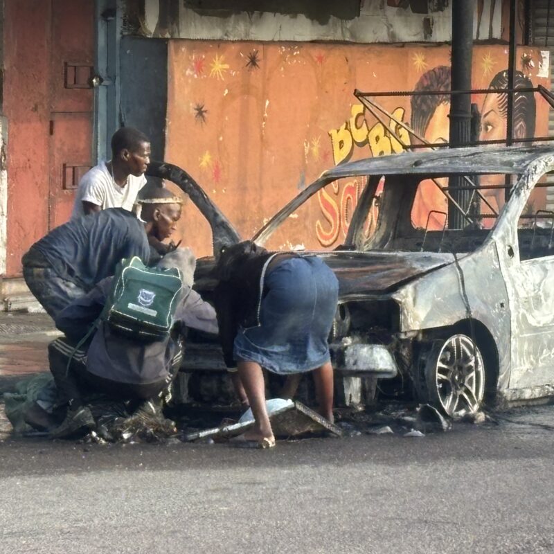 Homeless people stripping a burnt car in Durban CBD